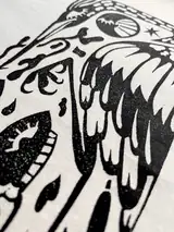 Detail of the Misguided Care print on a off-white T-shirt