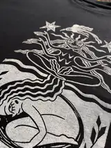 Detail of the Seed of Change print on a black T-shirt