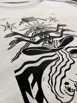 Detail of the Seed of Change print on a off-white T-shirt